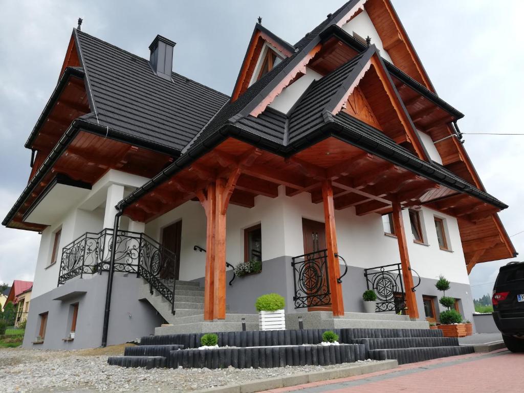 uma casa com um telhado preto em Kłabuk em Białka Tatrzanska