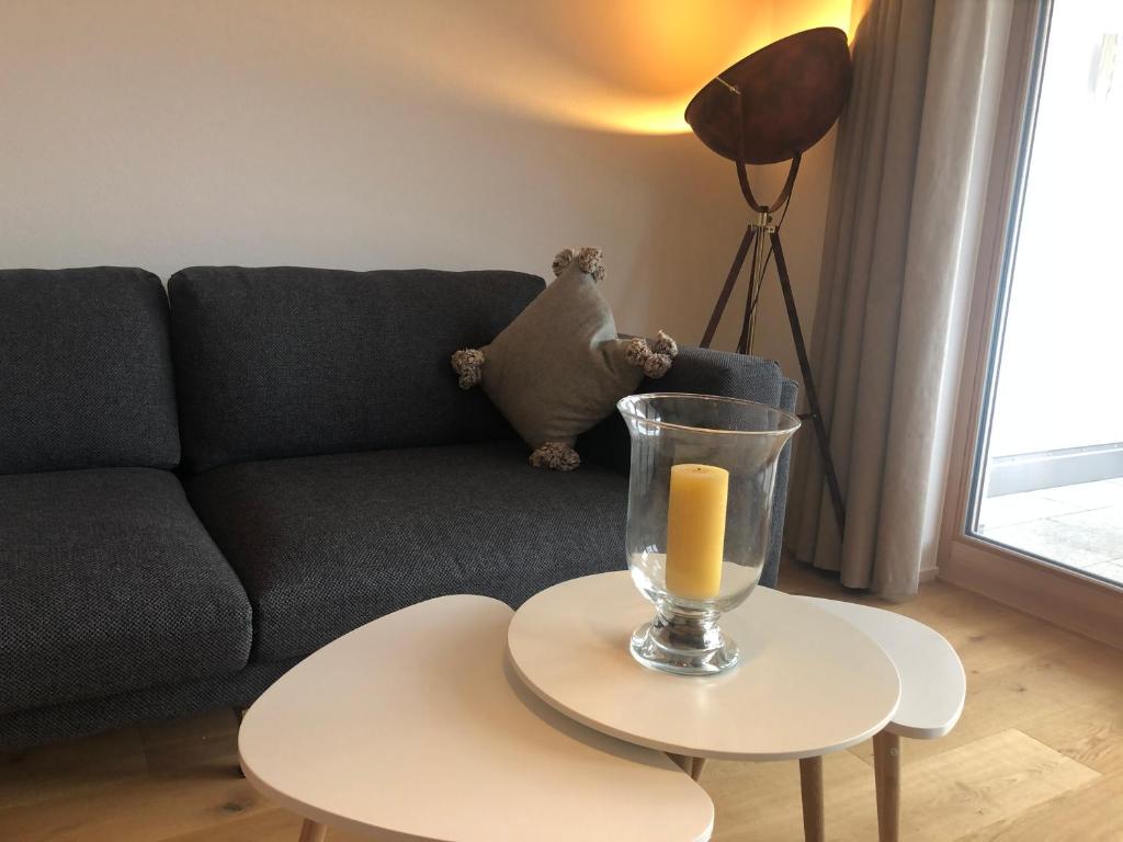 a living room with a couch and a candle on a table at Apartment Schliersee - Stylisch, zentral, familienfreundlich in Schliersee