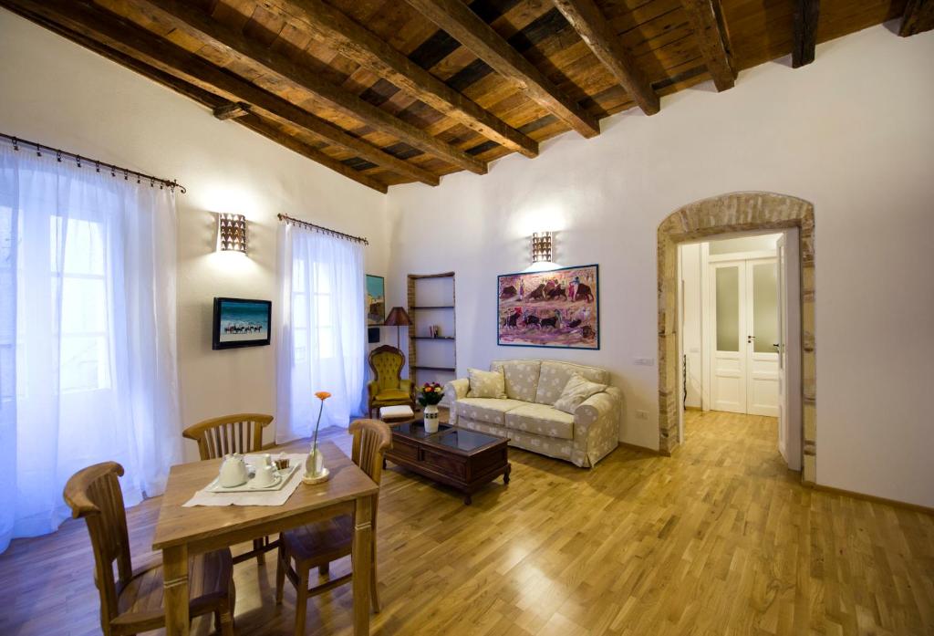 a living room with a table and a couch at Castelletto Suites in Cagliari