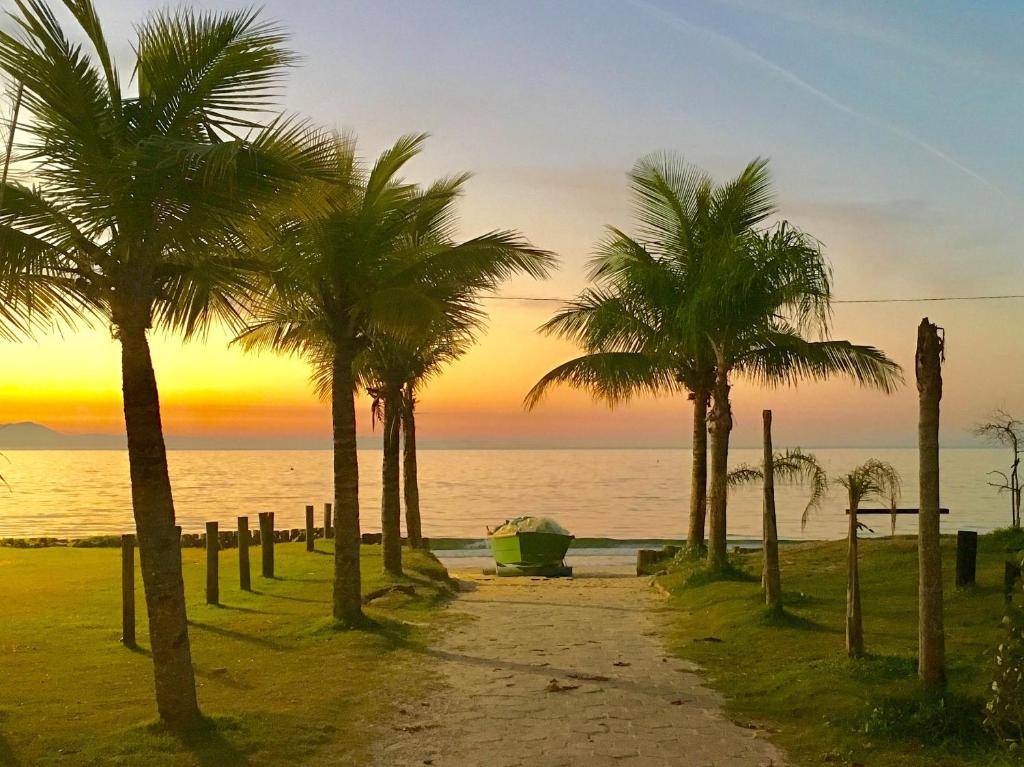 a group of palm trees on the beach at sunset at Las Gardenias in Florianópolis