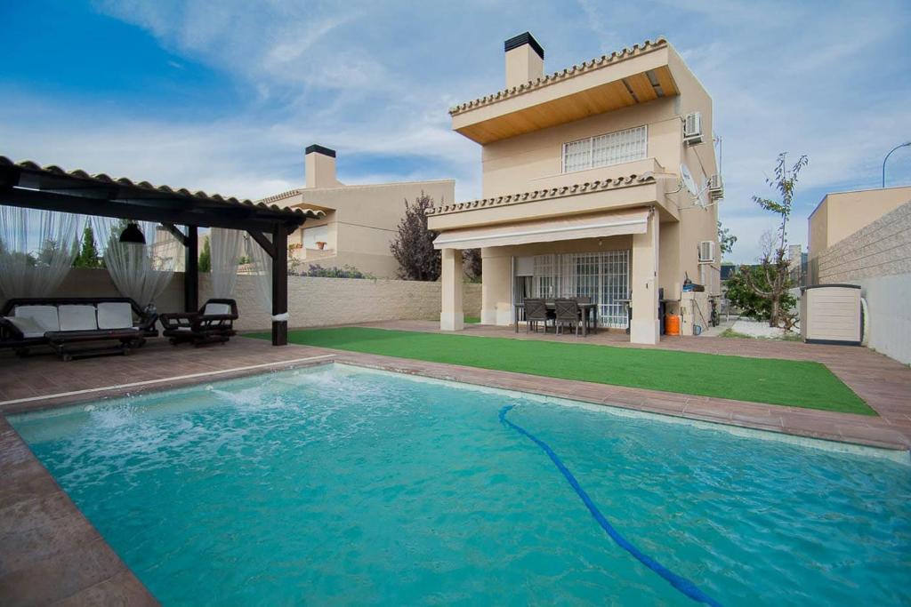 une grande piscine en face d'une maison dans l'établissement Granada-otura -Villa hoyo 7-NIEVE -CAMPO DE GOLF,PLAYA CERCANA CARGADOR ELECTRICO RAPIDO, à Otura
