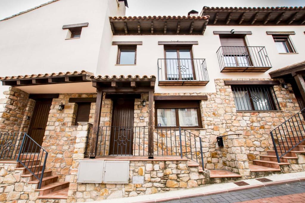 an old stone house with balconies on a street at Casa Rural Galana in La Puebla de Valverde