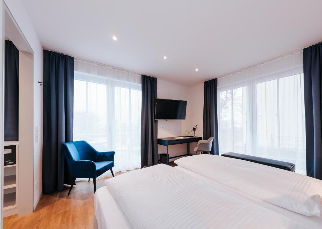 um quarto de hotel com uma cama, uma secretária e uma janela em HAIMHAUSERS Hotel Garni em Haimhausen