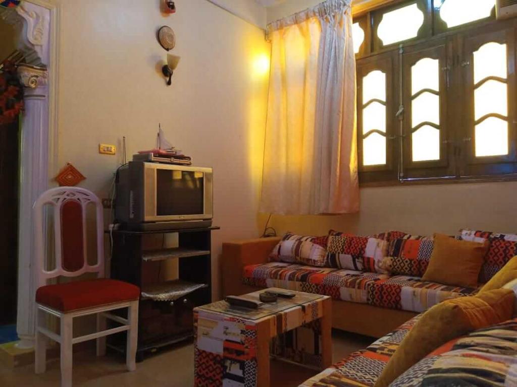 a living room with a couch and a tv at Roma House in Aswan