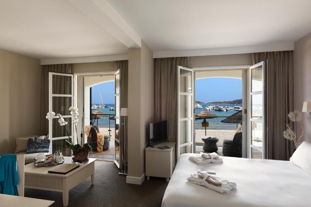 a hotel room with a bed and a view of the ocean at Le Pinarello in Sainte-Lucie de Porto-Vecchio