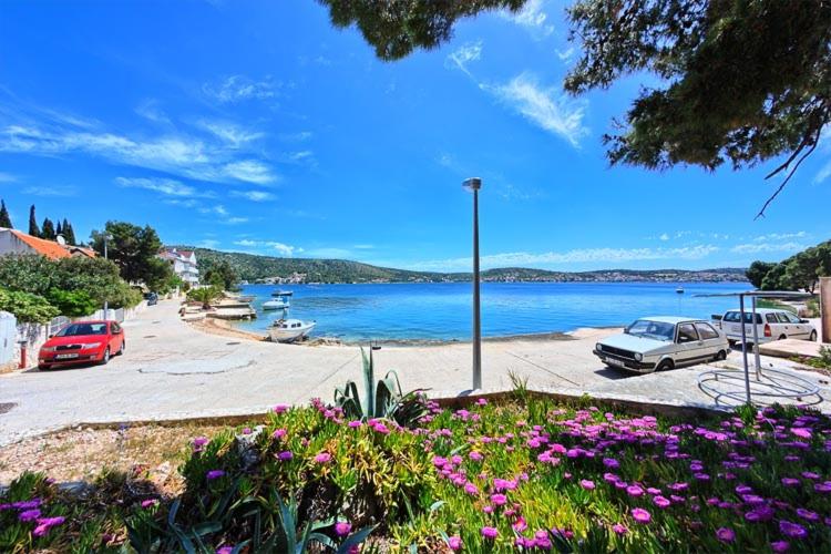 a group of cars parked next to a body of water at Apartments & Rooms Ruzmarin in Rogoznica