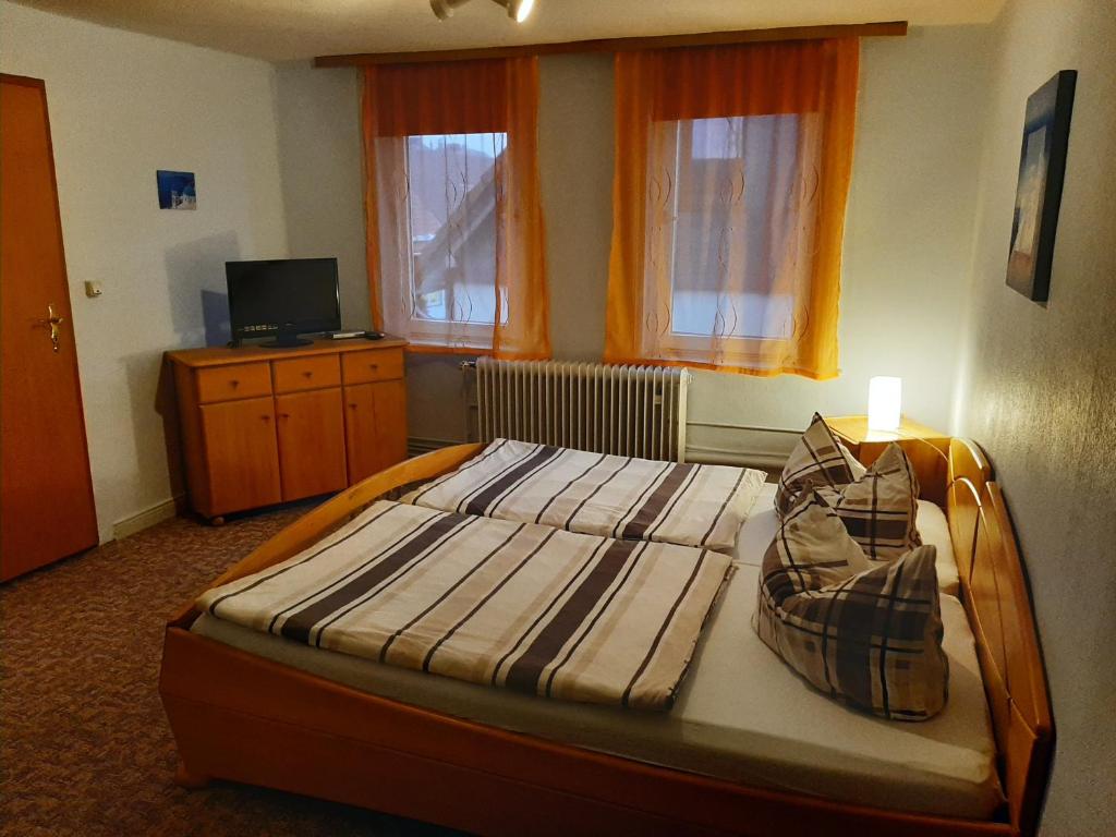 Apartments Carmen-Braunlage في برونلاغ: غرفة نوم بسرير مع اطار خشبي