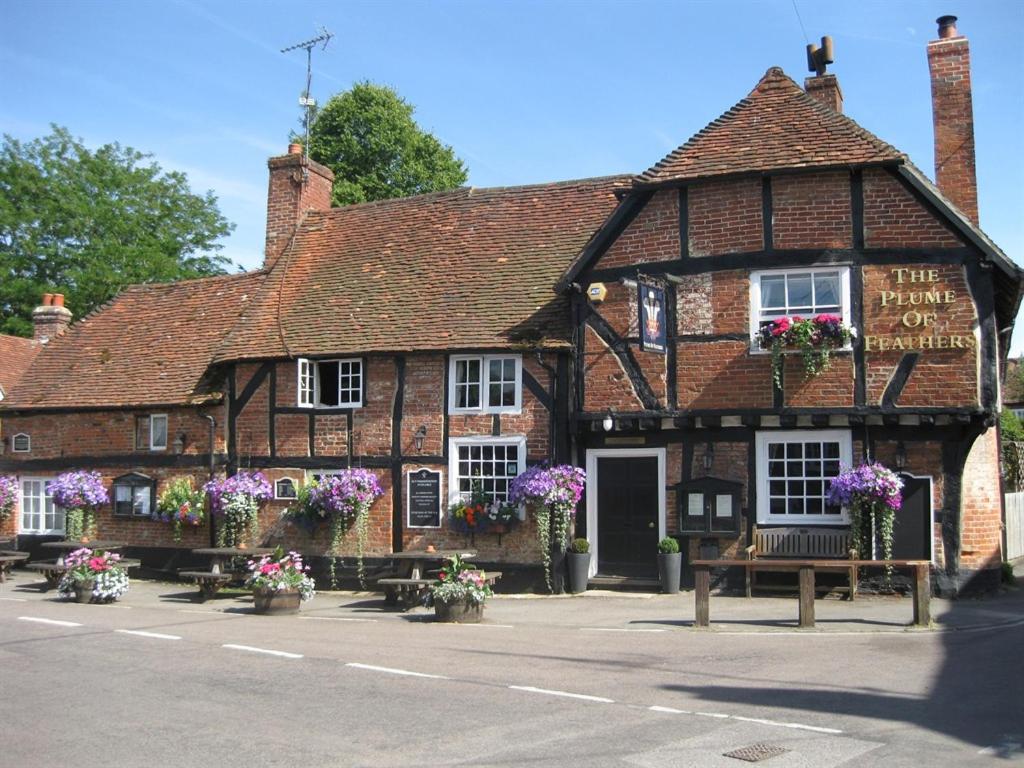 an old brick building with flowers in front of it at The Plume of Feathers in Farnham