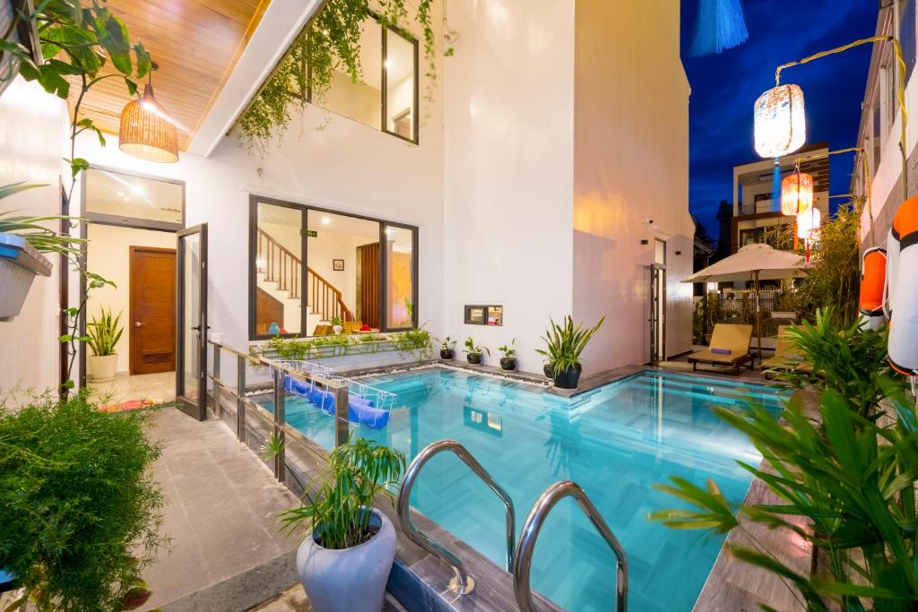 una piscina cubierta en una casa con plantas en Saclo Villa and Hostel, en Hoi An