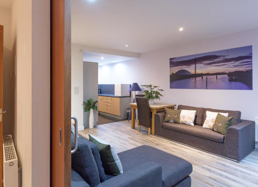 ein Wohnzimmer mit einem Sofa und einem Tisch in der Unterkunft Riverside West End Apartment in Glasgow