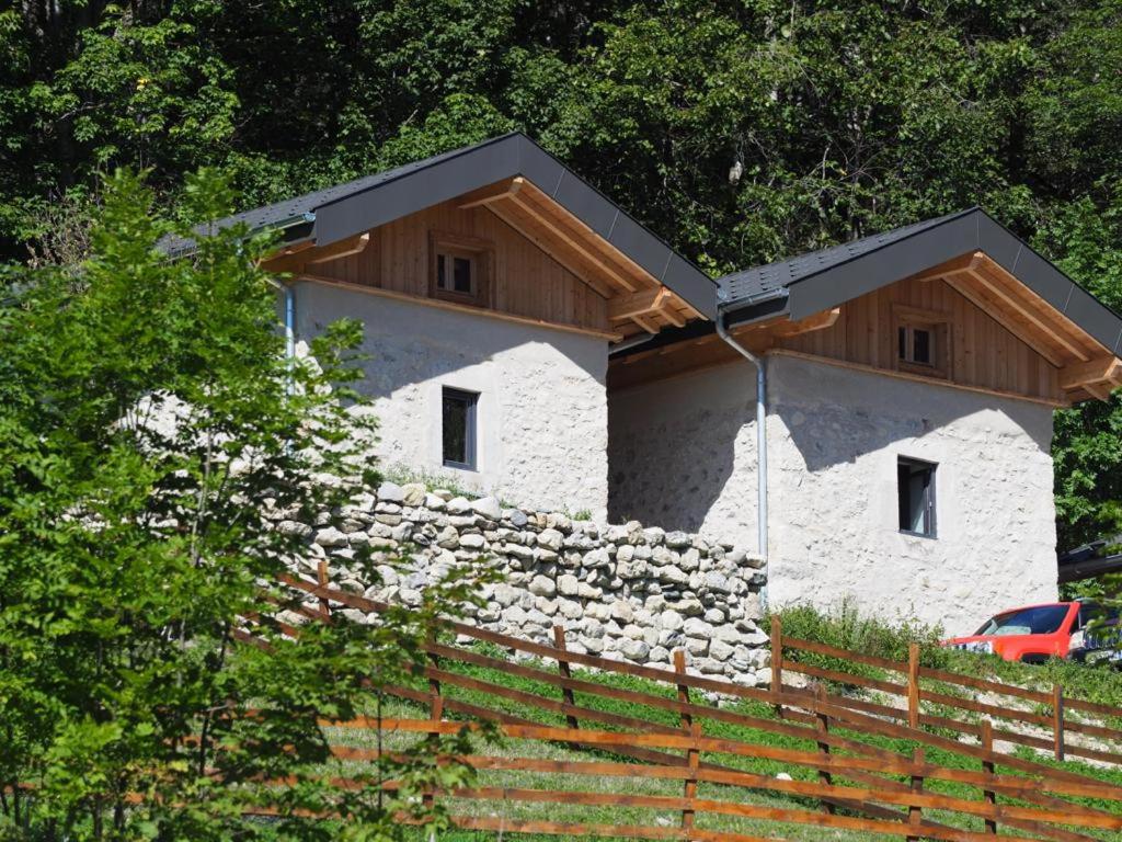 a house with a stone wall and a wooden roof at Les Maisons de la Glappaz in Mégevette