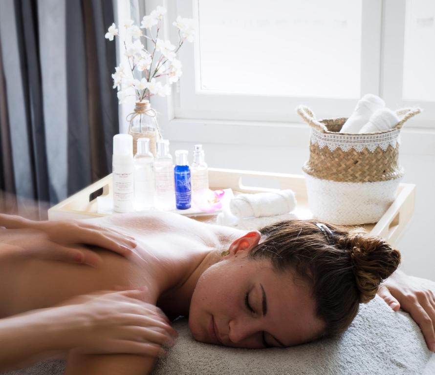 a woman laying on the floor in a massage room at Le Pinarello in Sainte-Lucie de Porto-Vecchio