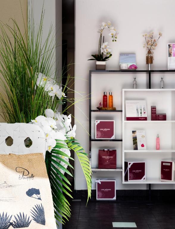 a bouquet of flowers in a room with shelves at Le Pinarello in Sainte-Lucie de Porto-Vecchio