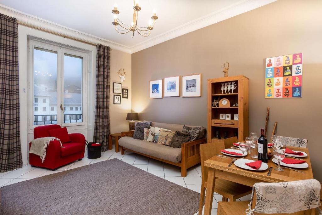 un salon avec une table et une chaise rouge dans l'établissement Le Majestic 76 - Chamonix All Year, à Chamonix-Mont-Blanc