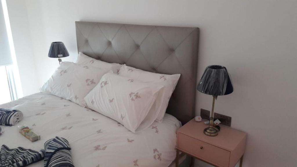 a bedroom with a bed with a headboard and two lamps at Ocean Village apartment in Gibraltar
