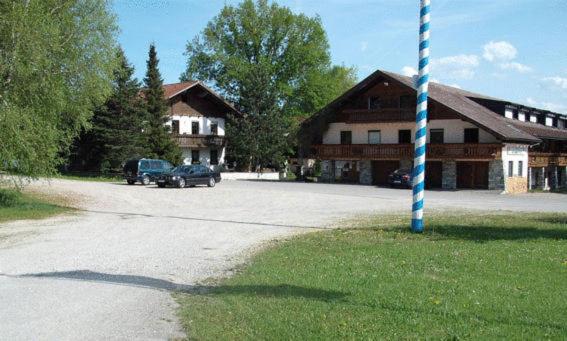 a parking lot in front of a building with a blue pole at Landgasthof Schweizerhof in Wonneberg