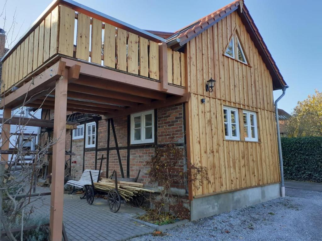 a large wooden house with a porch at Eggert's Ferienhaus zum Apfelgarten in Ilsenburg