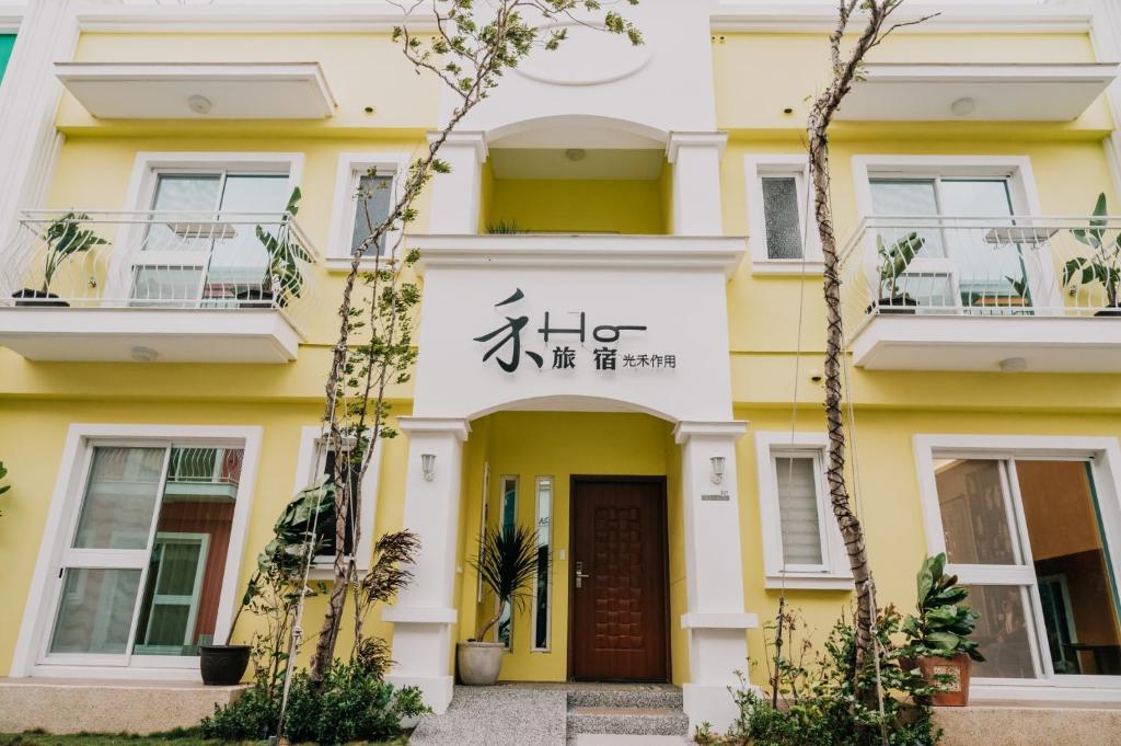 um edifício amarelo e branco com um sinal em 禾旅宿Ho Hostel 墾丁夢幻島 em Hengchun Old Town