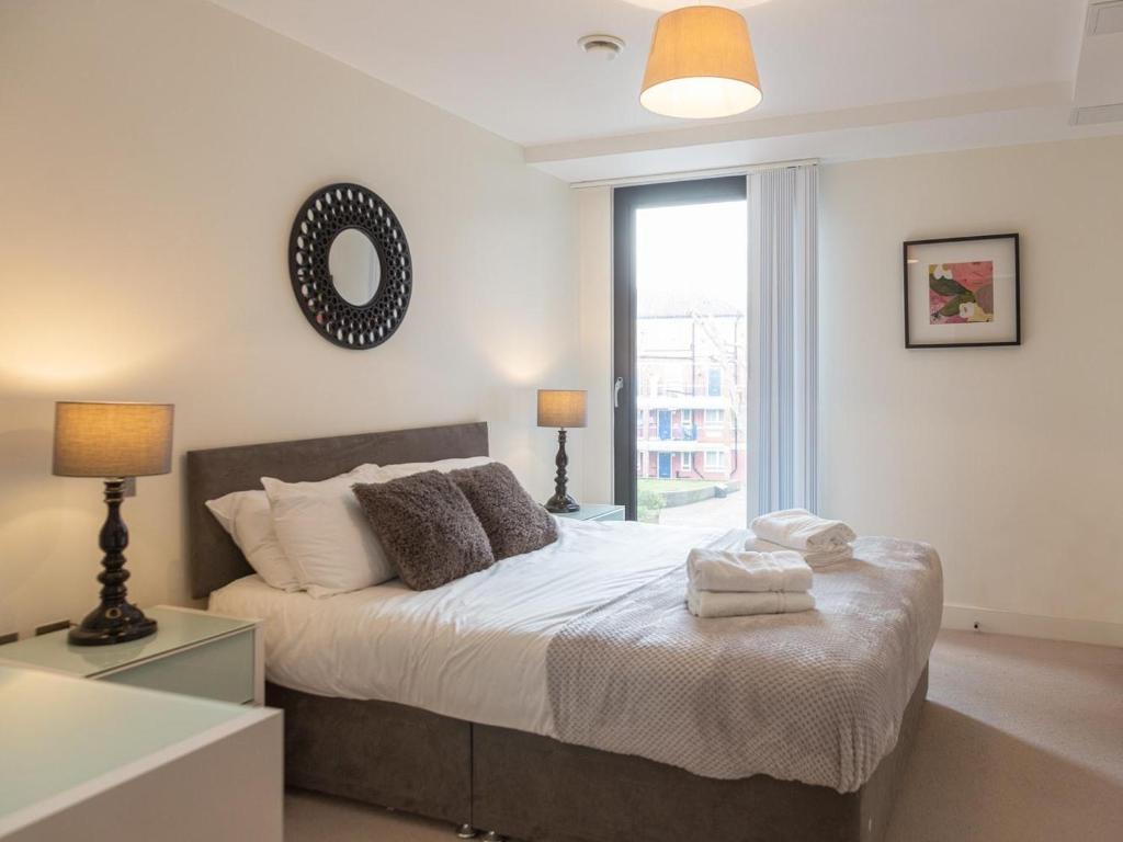 a bedroom with a bed with two lamps and a window at Central Tower Bridge Apartment in London