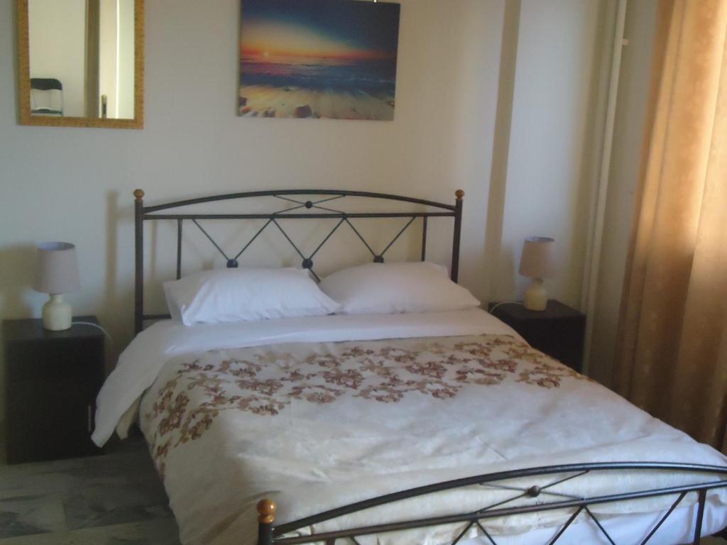 a bedroom with a large bed with a metal frame at Original house in Larisa