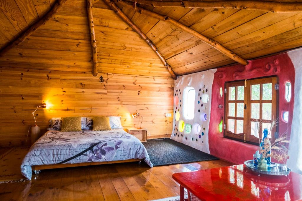 ein Schlafzimmer mit einem Bett in einer Holzhütte in der Unterkunft Casa Inspirada in Los Estancos