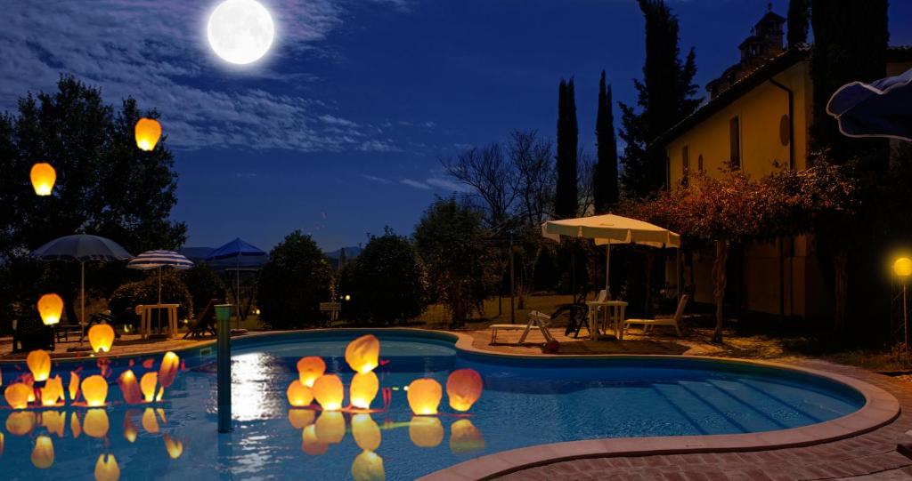 a swimming pool at night with a full moon at Subretia Residenze Di Campagna in Montefalco