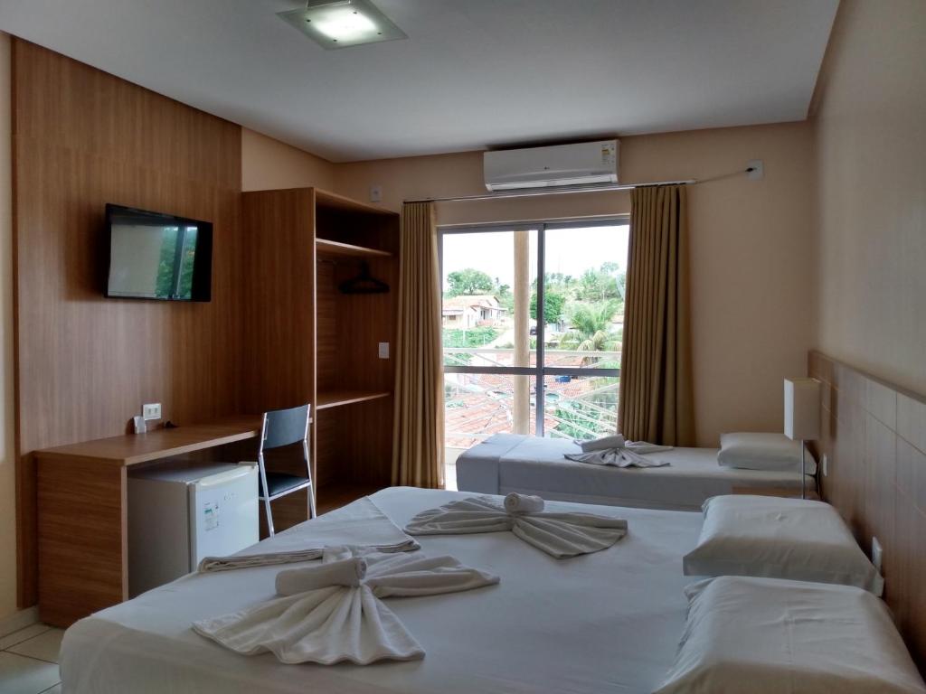 a hotel room with two beds and a window at Planeta Hotel in Colinas Do Sul