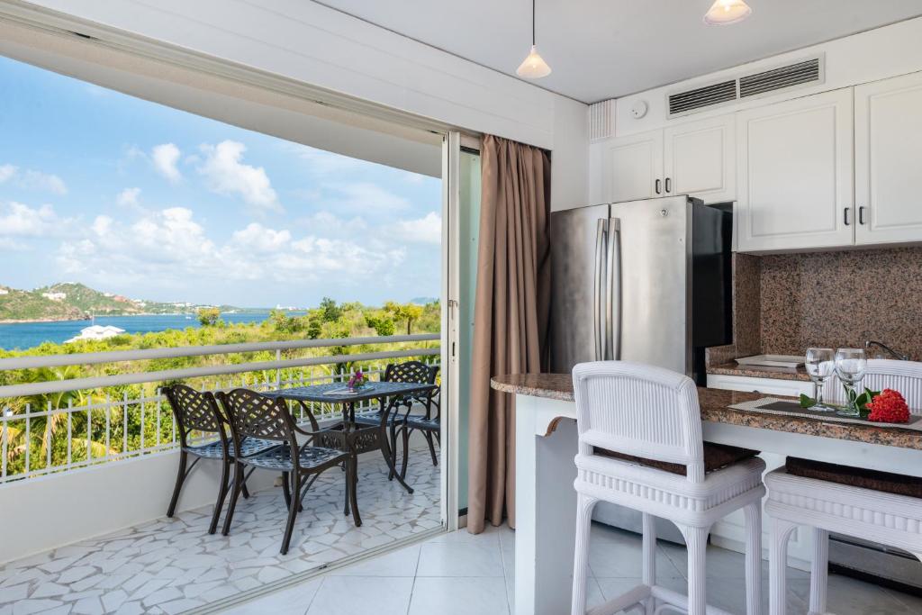 a kitchen with a balcony with a table and chairs at Sint Maarten Blue Dream Studio 6 in Cupecoy