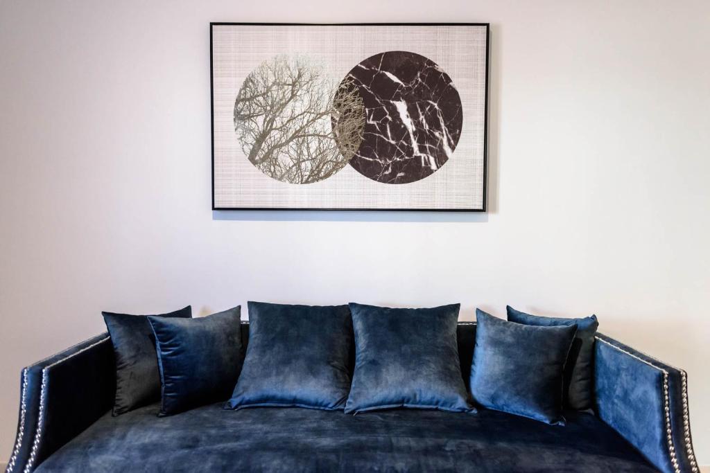 un sofá con almohadas azules sentadas bajo una foto en ''SteliosDimitra'' Guest House II in Nafplio en Nauplia