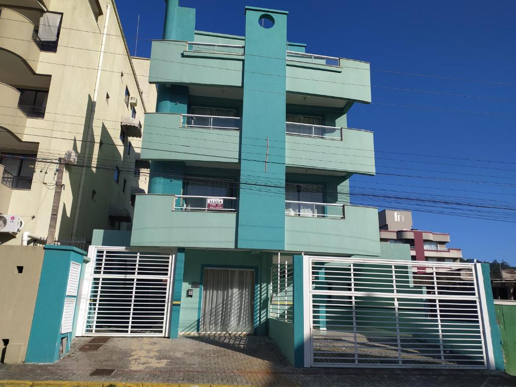 un edificio azul con una puerta delante en Apartamentos em Bombas, en Bombinhas