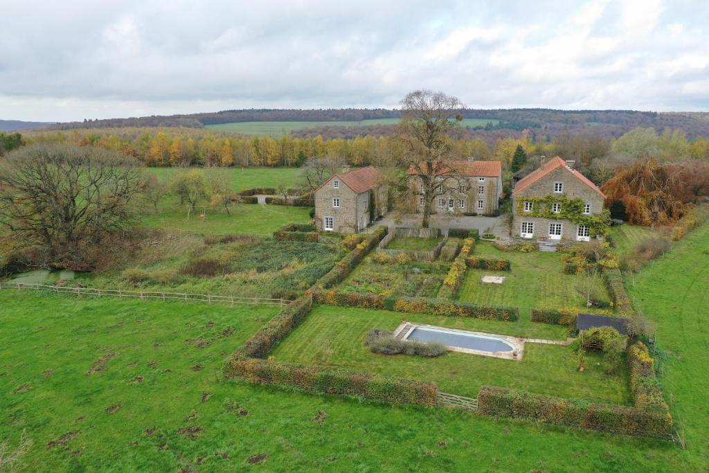 een luchtzicht op een groot huis met een zwembad in een veld bij B&B La Ferme de l'Airbois in Yvoir