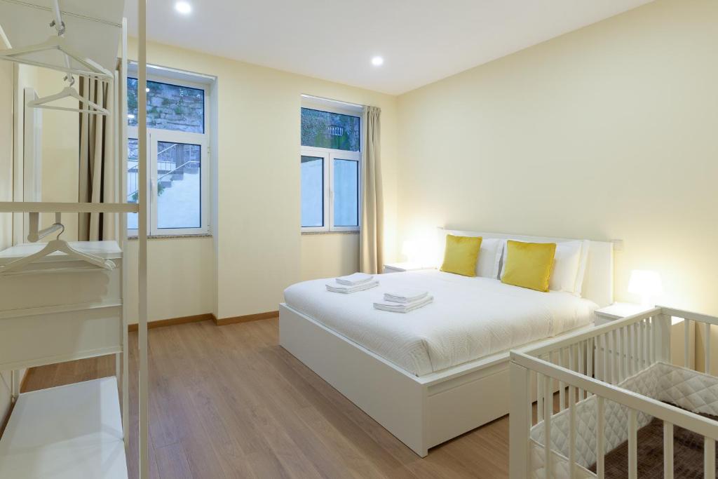 una camera bianca con un letto e due finestre di Yellow Tiles by PCALE a Porto