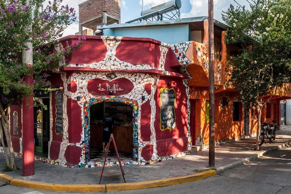 ein rotes Gebäude mit einem Gemälde an der Seite in der Unterkunft La Neofita in Mina Clavero