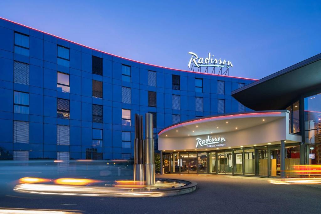 a large building with a sign on the side of it at Radisson Hotel Zurich Airport in Rümlang