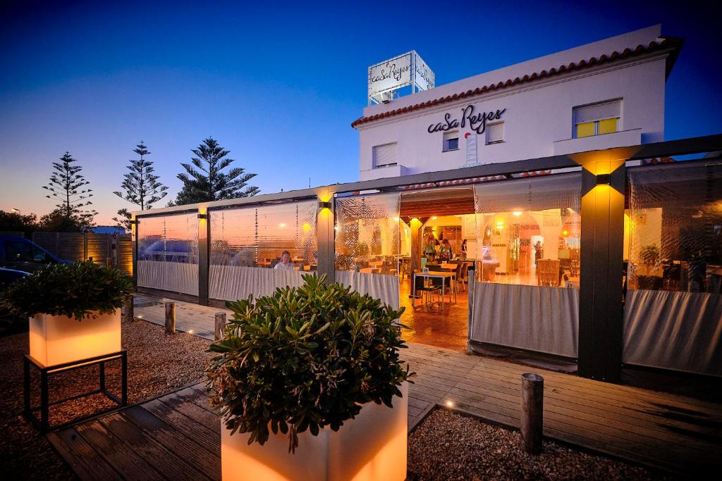 un restaurant avec des plantes en pot devant un bâtiment dans l'établissement Casa Reyes El Palmar, à El Palmar