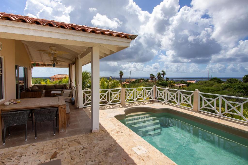 a house with a swimming pool and a patio with a table at Casa di Bon Bientu in Kralendijk