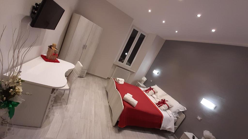 Habitación pequeña con cama roja y escritorio. en B&B Da Daniela, en Magliano deʼ Marsi