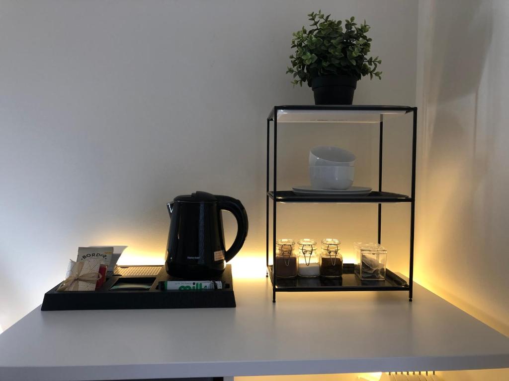 a shelf with a coffee pot and glasses on it at The Duplex Margate with Deck & Living Space Air Conditioning in Margate
