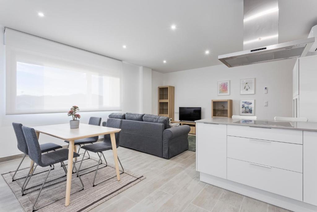 cocina y sala de estar con mesa y sofá en APARTAMENTO LUMINOSO EN CANGAS - B, en Cangas de Morrazo