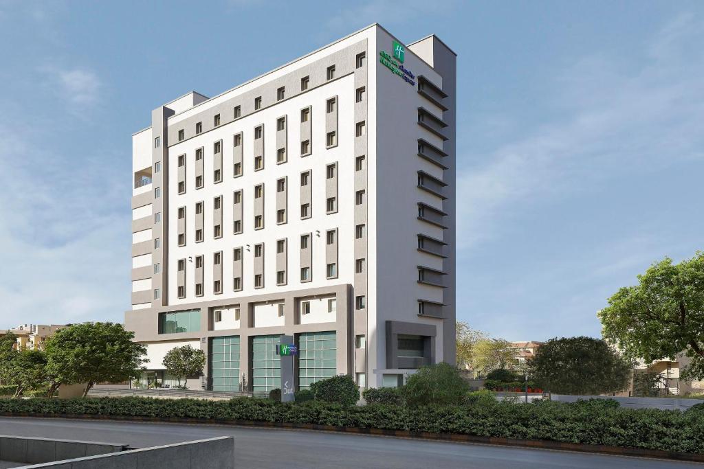 アーメダバードにあるHoliday Inn Express Ahmedabad Prahlad Nagar, an IHG Hotelの白い建物の描写