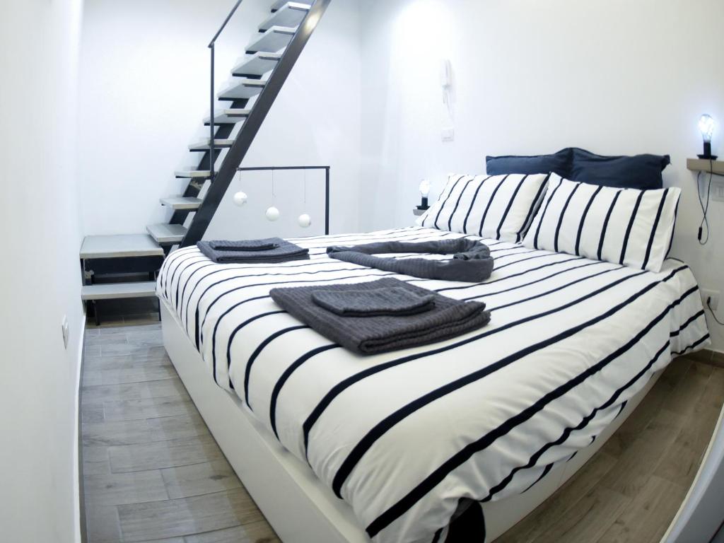 Schlafzimmer mit einem Bett mit schwarzen und weißen Streifen in der Unterkunft Corte32 in Bari