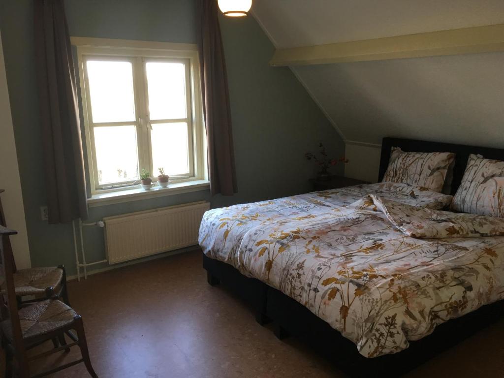 - une chambre avec un lit et 2 fenêtres dans l'établissement Warmoes tuinderswoning, à Nimègue