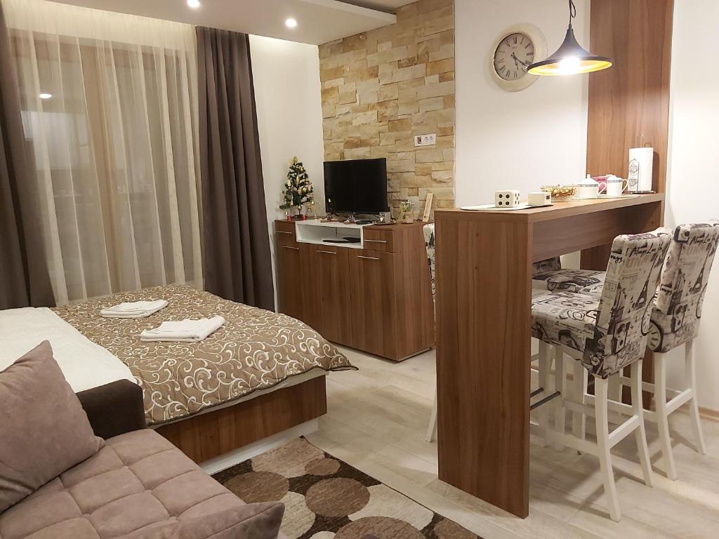 a room with a bed and a table and a desk at AMI apartman Kopaonik in Kopaonik