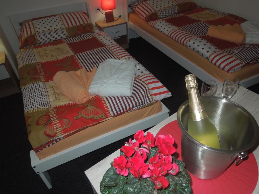 a room with two twin beds and a table with flowers at Penzion Cristal in Rossitz