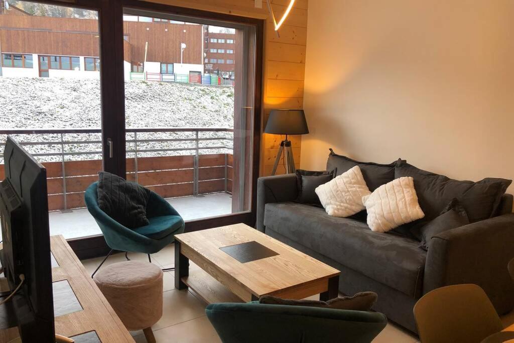 APPARTEMENT 8 personnes LODGES A505 في La Plagne Tarentaise: غرفة معيشة مع أريكة وطاولة