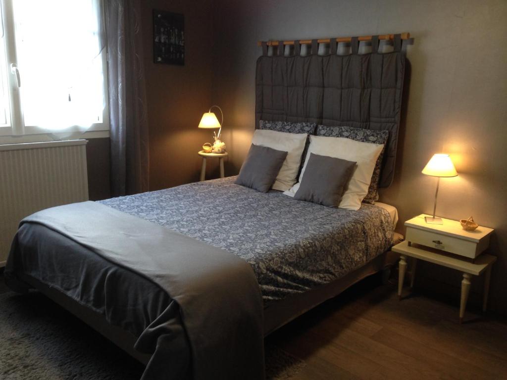 ein Schlafzimmer mit einem großen Bett und zwei Lampen in der Unterkunft Chambre d'Hôtes Hola in Laval