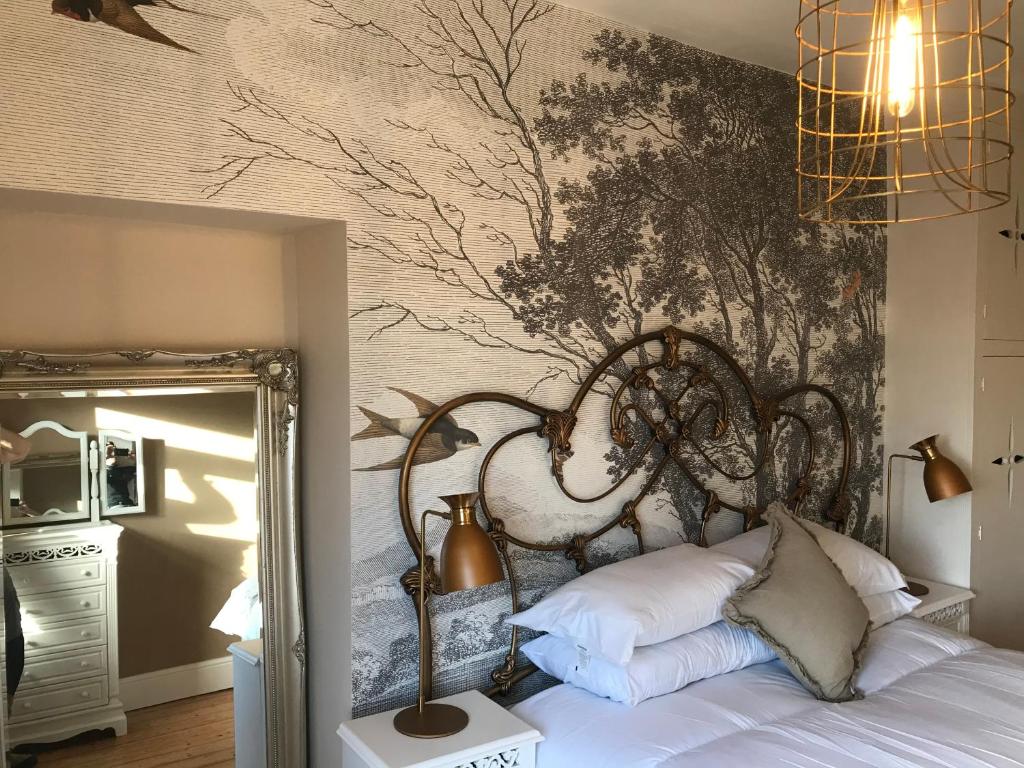 Schlafzimmer mit einem Bett mit Wandgemälde in der Unterkunft Inglenook Cottage in Grange Over Sands