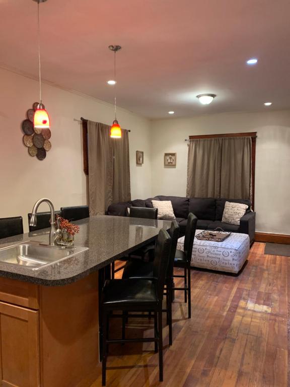 a kitchen and living room with a sink and a couch at Cozy 4 Bedroom Home Accommodates 10 in Niagara USA in Niagara Falls