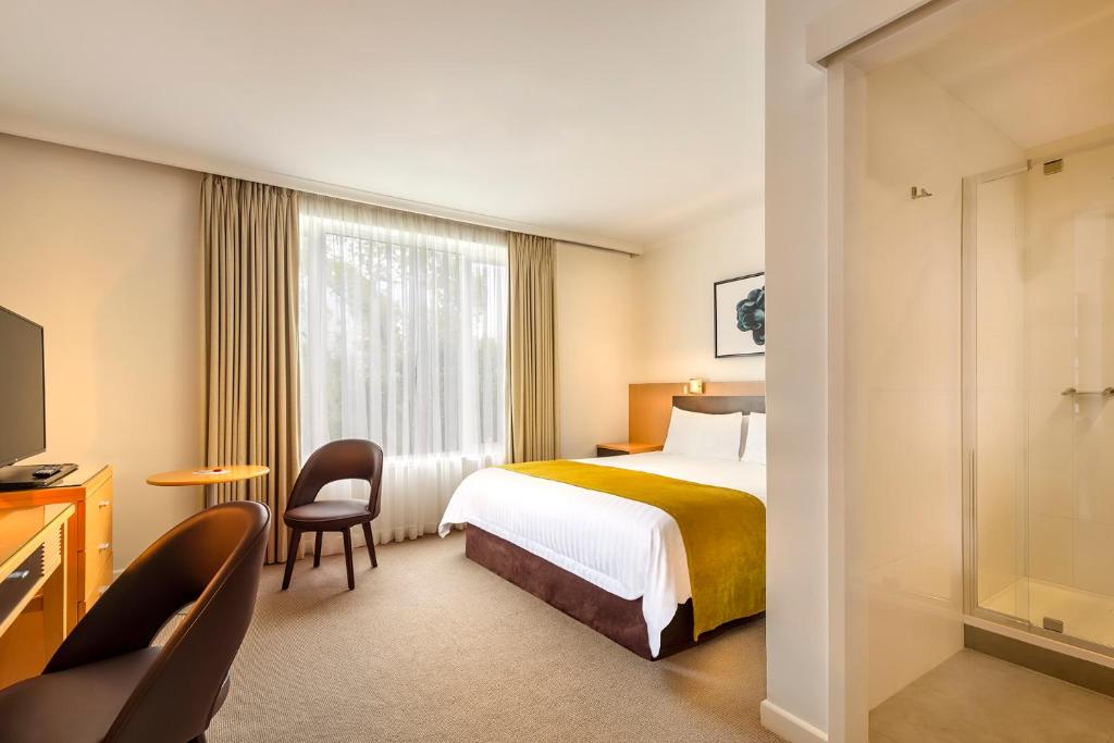 a hotel room with a bed and a window at BEST WESTERN PLUS Travel Inn in Melbourne