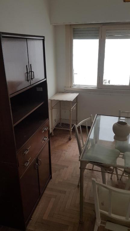 a living room with a glass table and a cabinet at Departamento 2 amb centro in Mar del Plata